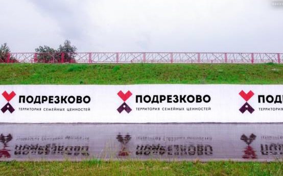 Длинная подпорная стена в парке с логотипами «Подрезково»